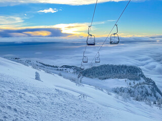 Spectacular view of the morning sky and ungroomed slopes of a closed ski resort.
