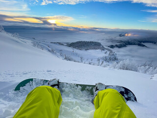 POV: Stunning view of wintry scenery as you sit in snow during snowboarding trip