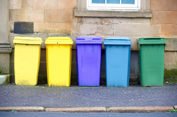 Wheelie bin colour blue, purple and black for refuge collection outside house in a row