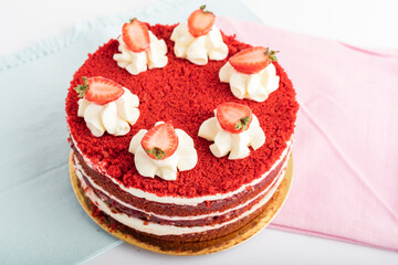 Delicious cake with slices of fresh strawberries on a blue and pink napkin. Festive dessert