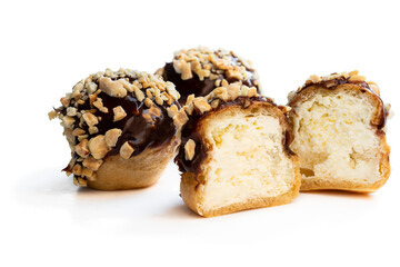 Homemade profiteroles covered with chocolate isolated on white