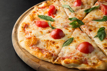 Mozzarella pizza with tomatoes on a wooden pizza plate