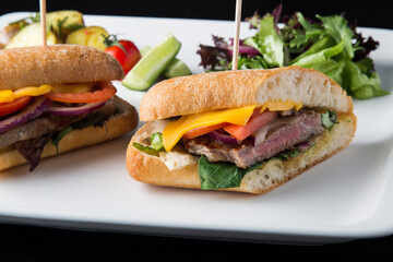 Roast beef sandwiches cut in half in a white plate 