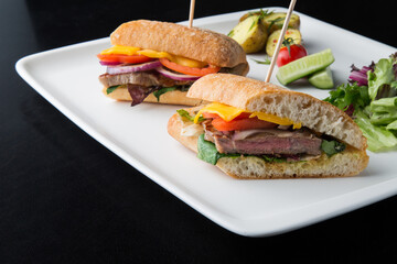 Roast beef sandwiches cut in half in a white plate 