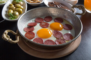 Fried egg with sausage on a black background