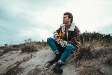 Young man playing guitar outdoor 