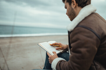 Boy reads a book on the beach alone
