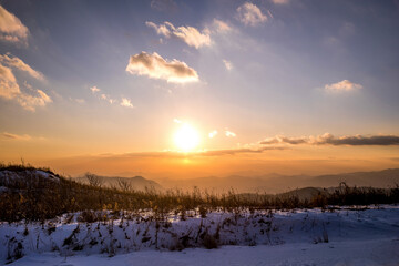 노을 속 눈 쌓인 겨울산의 풍경