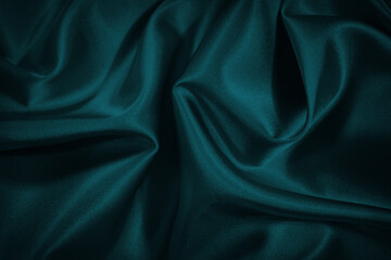 Black blue green abstract background. Dark green silk satin texture background. Beautiful wavy soft...