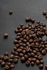 Roasted coffee beans scattered on dark background