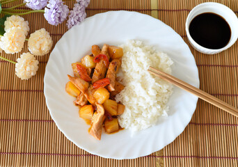 Chicken in sweet and sour sauce with pineapple, paprika and rice. asian cuisine