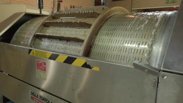 Esposende, Portugal, September 30, 2020 - White wine grape juice running out of the press machine in a wine cellar.