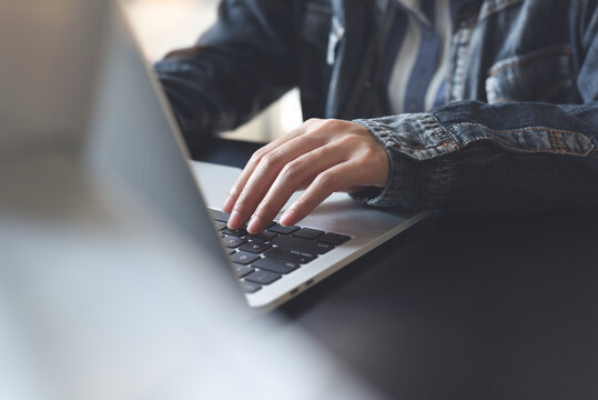Close up of woman hands typing on laptop computer, online working from home office