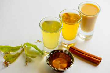 Fresh organic apple cider with apples and cinnamon over white background. Close up three glasses.