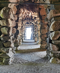 Fototapeta premium wonderful large stone corridor near a castle with a light at the end