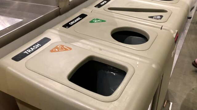 Woman throwing the trash to the garbage can inside Ikea store