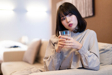 寝室で水を飲む女性