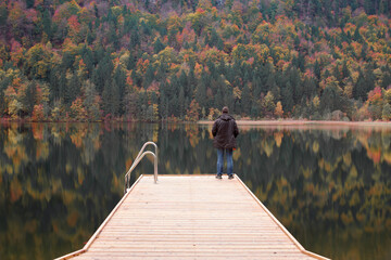 A man alone looks at the autumn lake