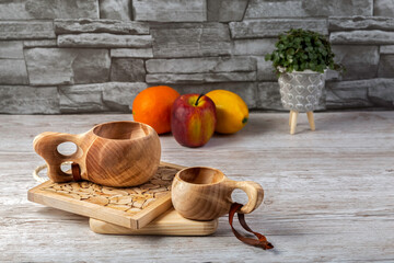 Traditional Sami wooden cups on a wooden table, on wooden planks stands. Kuksa. Finnish wooden cups. Finnish culture.