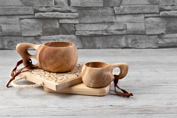 Traditional Sami wooden cups on a wooden table, on wooden planks stands. Kuksa. Finnish wooden...