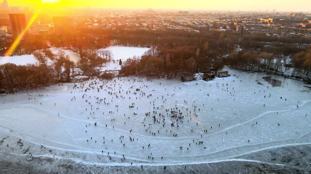 Aerial view of a large crowd of people ice skating near the Flevopark on a frozen lake in Amsterdam, The Netherlands.
