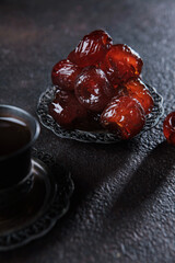 Dates in sugar glaze. Dried fruits for dessert. Macro photo on a dark background. Vertical photo.