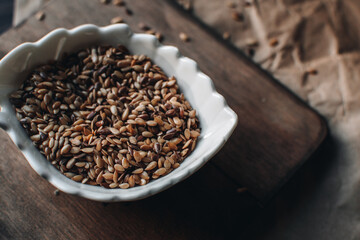Organic food concept with flax seeds on a wooden background. Bowl with flax seeds.