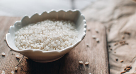 Organic food concept with white rice on a wooden background. Bowl with rice.