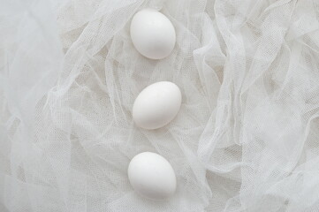 Close up composition of white eggs  on white textured background, top view, copyspace