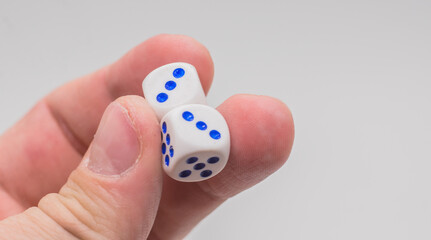 Two dice with numbers three in hand.
