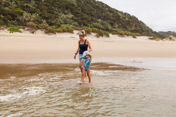 Family play in the water on the beach.