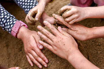 children's hands playing sand