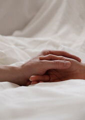 hands of female and male lying on bed. Sensual. Couple love. 
