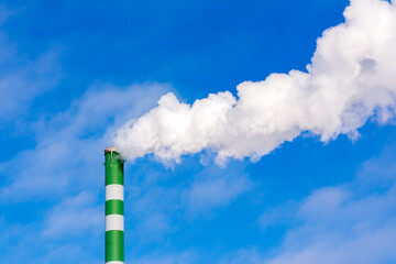 One Industrial smoke pipe from chimney on blue cloudy sky.