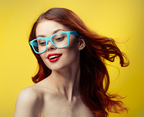 woman with bare shoulders red lips blue glasses