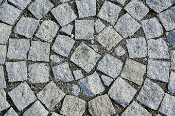 background - fragment of an old sidewalk paved with granite paving stones