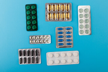Pharmaceutical medication and medicine pills in packs on blue table