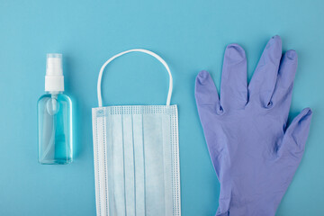 Antivirus protection - medical mask, disposable gloves and antiseptic gel on a blue background
