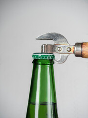 Close-up of the neck of a beer bottle with a bottle opener