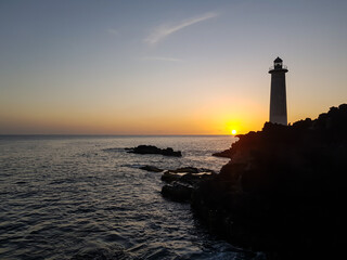 lighthouse at sunset in the sea