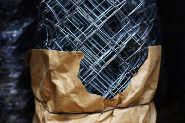 Metal mesh for making a fence. The material in a roll lies on the window of a hardware store. Close-up