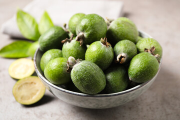 Fresh green feijoa fruits on light grey table, closeup