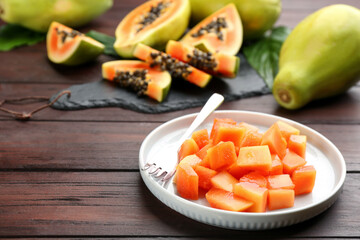 Diced fresh ripe papaya on wooden table