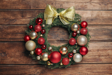 Obraz na płótnie Canvas Beautiful Christmas wreath with festive decor on wooden background