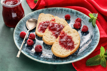 Toasts with sweet raspberry jam on color background