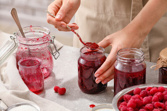 Woman with jars of sweet raspberry jam