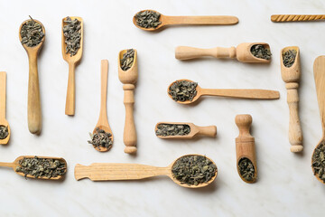 Composition with dry green tea leaves on light background