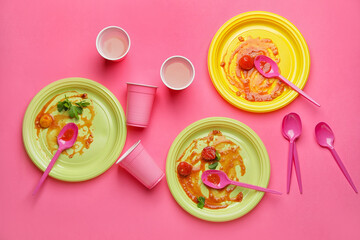 Dirty plastic tableware on color background