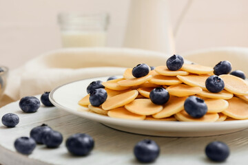 Plate of tasty pancakes with fresh blueberry on light background, closeup