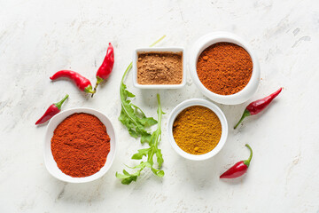 Bowls with different spices on light background - obrazy, fototapety, plakaty